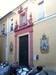 Fachada exterior de la iglesia con su portalada clásica y retablos cerámicos