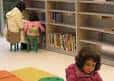Vista del interior de la biblioteca con estanterías y zona de lectura infantil