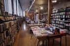 Vista interior de la librería con estanterías y mesas de exposición de libros
