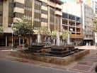 Fuente ornamental en la Plaza de Martí y Monsó con arquitectura urbana de fondo