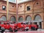 Patio interior del museo con exposición de camiones de bomberos antiguos y arquería de ladrillo