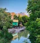 Vista exterior del local El Corazón Verde junto al canal rodeado de frondosa vegetación
