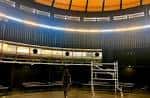 Interior de la sala circular polivalente con estructura de madera y pasarelas