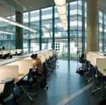 Espacio interior de la biblioteca con puestos de lectura y grandes ventanales