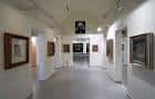 Galería interior con exposición de pinturas en marcos clásicos