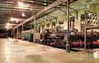 Interior del museo con antiguas locomotoras de vapor bajo la marquesina de la estación