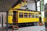 Tranvía histórico de color amarillo expuesto en el interior del museo