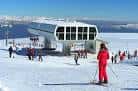 Instalaciones de los remontes y zona de pistas con esquiadores durante el invierno