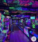 Interior de la sala con iluminación de neón y paredes decoradas con grafitis