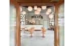 Vista interior del restaurante con decoración moderna, lámparas de globo y ventanales clásicos