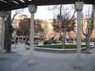 Perspectiva de la plaza desde los soportales con columnas de piedra