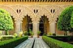 Patio interior con arquería labrada y zonas ajardinadas