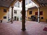 Patio interior del palacio con columnas de piedra y techumbre de madera