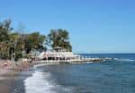 Fachada blanca de los Baños del Carmen frente al mar en un día despejado