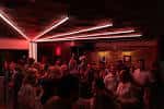 Ambiente interior del local con iluminación de neón roja durante un evento
