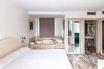 Interior de una habitación suite con cama amplia y bañera de hidromasaje