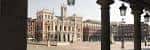 Vista de la plaza y el Ayuntamiento enmarcada por las columnas de los soportales