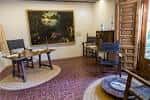 Estancia interior con escritorio de madera y cuadros de época