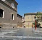 Espacio abierto de la plaza con pavimentación moderna y edificios de ladrillo