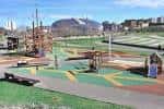 Área recreativa infantil con estructuras de madera y zonas de esparcimiento