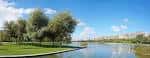 Paisaje del estanque y vegetación del parque con la ciudad al fondo