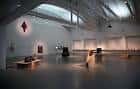 Interior de una de las salas de exposiciones con techos industriales y luz natural