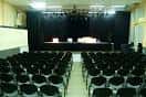 Vista del interior del salón de actos con escenario y filas de asientos
