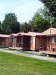 Bungalows de madera con porche alineados frente a una zona de césped