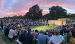 Público disfrutando de una actuación al aire libre en el Brighton Open Air Theatre bajo un cielo de atardecer