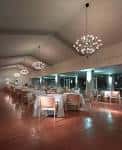 Salón de eventos interior con iluminación moderna y mesas dispuestas