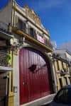 Fachada tradicional con gran arco y puerta de madera de la Casa Hermandad de la Soledad