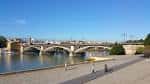 Amplia explanada del paseo a orillas del río con vistas al Puente de Triana