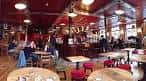 Vista amplia del interior del pub con mesas, taburetes y ambiente acogedor