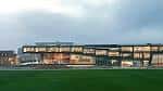 Edificio contemporáneo de ciencias y deportes de Brighton College con iluminación nocturna