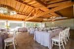 Salón interior para banquetes con techos de madera y mesas decoradas