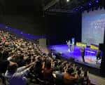 Interior del auditorio con público durante un evento en el escenario principal
