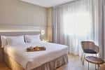 Interior de una habitación moderna y luminosa con cama doble y servicio de desayuno
