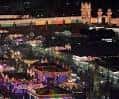 Vista nocturna panorámica del recinto ferial iluminado con la portada tradicional al fondo