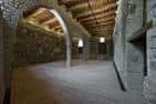 Sala interior rehabilitada con muros de piedra y techos de madera