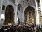 Vista del interior de la iglesia mostrando el retablo mayor y la nave central