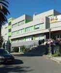 Edificio contemporáneo del colegio con detalles en color verde y acceso principal