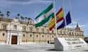 Entrada al Parlamento de Andalucía con las banderas oficiales y el rótulo institucional