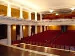 Vista panorámica del interior del teatro con sus columnas blancas, palcos y patio de butacas