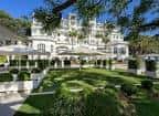 Jardines exteriores del hotel con zonas de descanso y arquitectura histórica