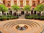 Patio central del Hospital de los Venerables con su característica fuente circular y arquerías