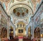 Vista general del interior de la iglesia barroca con frescos en las paredes y el altar mayor