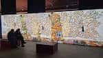 Sala de proyecciones inmersivas con obras de arte a gran escala y zona de descanso