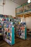 Vista del espacio de la librería mostrando las estanterías y un altillo de madera