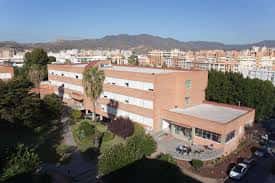 Fachada exterior de la facultad con zonas ajardinadas y vistas a la ciudad