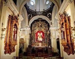 Vista del interior de la capilla con el retablo mayor y la cúpula decorada